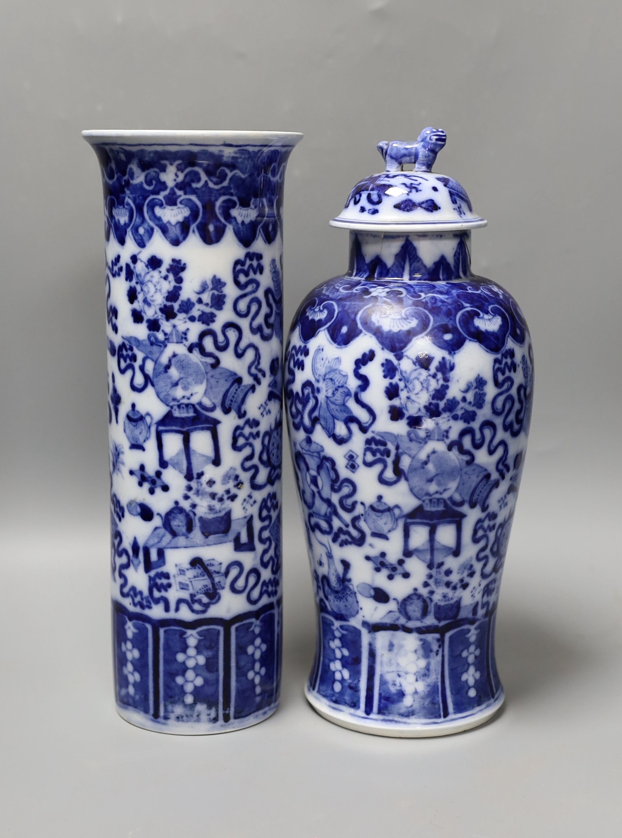 A Continental blue and white sleeve vase and a vase and cover (a.f.) 30.5cm